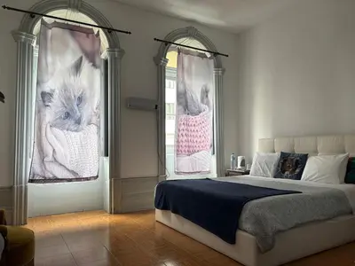 a bedroom with a bed and a tv and chairs at Residência Céu Azul in Porto