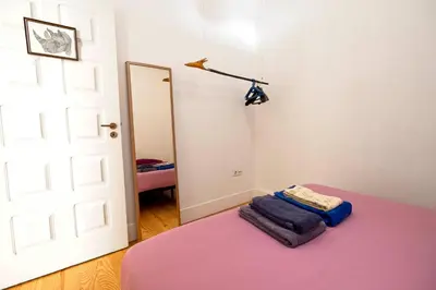 a room with a door and a bed with a purple blanket at Ribeira Smart Flat in Porto