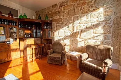 a living room with two chairs and a stone wall at Ribeira Smart Flat in Porto