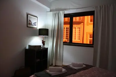 a bedroom with a window with a bed and a lamp at Alegria Rooms in Porto
