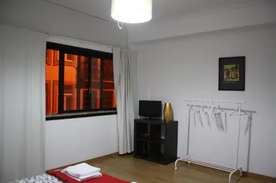 a white room with a bed and a window at Alegria Rooms in Porto