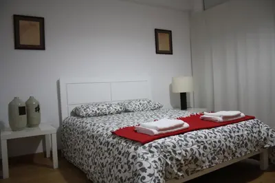 a bedroom with a bed with two towels on it at Alegria Rooms in Porto