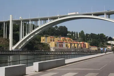 a bridge over a river with buildings under it at Alegria Rooms in Porto