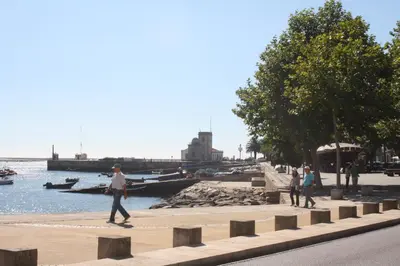 a group of people walking on a sidewalk near the water at Alegria Rooms in Porto