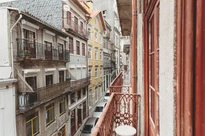 an alley between buildings with cars parked on a balcony at Ribeira Smart Suite in Porto