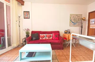 a living room with a red couch and a table at Ribeira Smart Suite in Porto