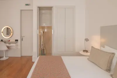 a white bedroom with a bed and a desk at Fil's Place in Porto