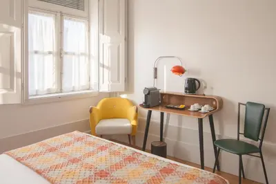 a bedroom with a bed and a table and a chair at Fil's Place in Porto