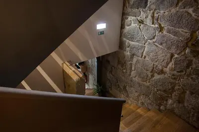 a staircase in a building with a stone wall at Belomont52 Guest House in Porto