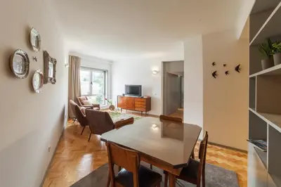 a dining room and living room with a table and chairs at CdC Apartments by Casa do Conto in Porto