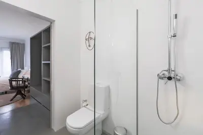 a bathroom with a toilet and a glass shower at CdC Apartments by Casa do Conto in Porto