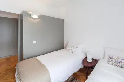 two beds in a room with white walls at CdC Apartments by Casa do Conto in Porto