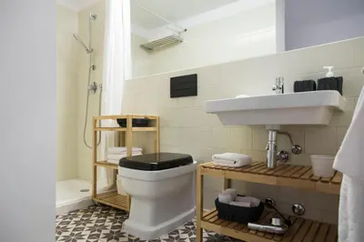a bathroom with a white toilet and a sink at Studio 77 in Porto