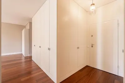 an empty room with white cabinets and wood floors at VIVA Aliados Spacious & Bright Flat in Porto