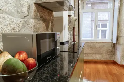 a kitchen with a bowl of apples and a microwave at Authentic Porto Apartments in Porto