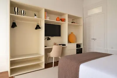 a bedroom with a bed and a desk with a television at Oporto Comfort Charming Cedofeita - Free Parking in Porto