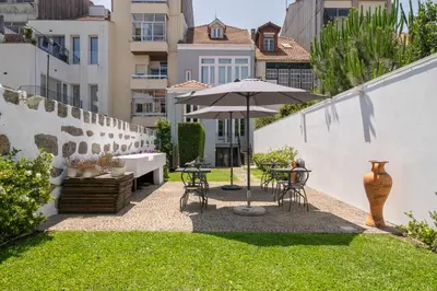 a patio with an umbrella and a table and chairs at Oporto Comfort Charming Cedofeita - Free Parking in Porto