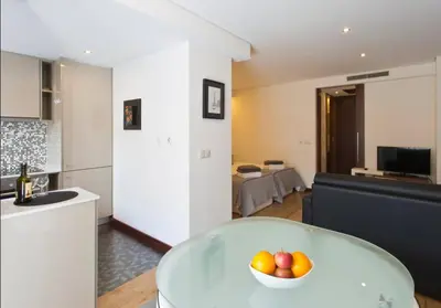 a kitchen and living room with a bowl of fruit on a table at I love alegria in Porto