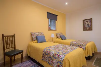 two beds in a room with yellow walls at Casa do Cristelo in Porto
