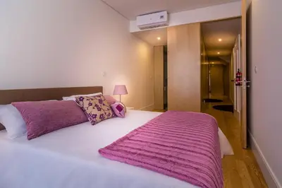 a bedroom with a large white bed with a purple blanket at Casa d'Alma by Oporto Soul in Porto