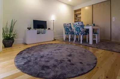 a living room with a table and chairs and a rug at Casa d'Alma by Oporto Soul in Porto