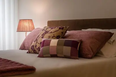 a bed with several pillows and a lamp on it at Casa d'Alma by Oporto Soul in Porto