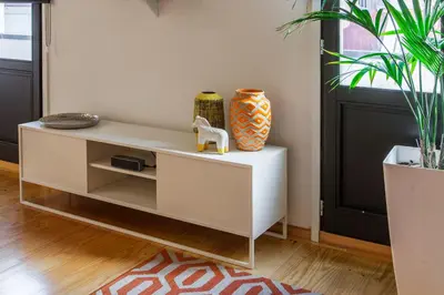 a white cabinet in a living room with a vase at Oporto Local Studios in Porto