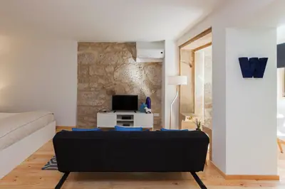 a living room with a couch and a tv at Oporto Local Studios in Porto