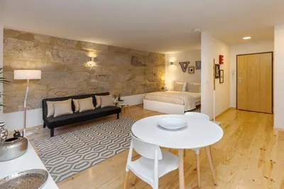 a living room with a bed and a table at Oporto Local Studios in Porto