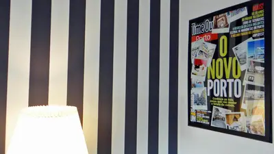 a wall with a poster and a lamp in a room at Design Apartment Porto Downtown in Porto