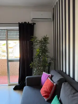 a living room with a blue couch with colorful pillows at Design Apartment Porto Downtown in Porto