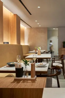 a restaurant with tables and chairs and people in the background at PortoBay Teatro in Porto