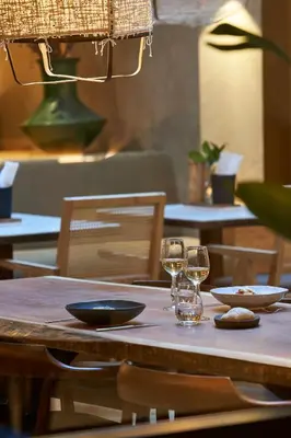 a wooden table with two glasses of wine on it at PortoBay Teatro in Porto