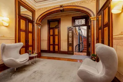 a lobby with two chairs and a clock on the wall at YOUROPO - Bolhao in Porto