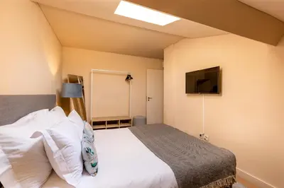 a bedroom with a bed and a flat screen tv at YOUROPO - Bolhao in Porto