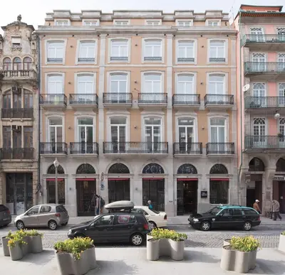 a large building with cars parked in front of it at The Editory House Ribeira Porto Hotel in Porto