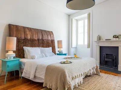 a bedroom with a large bed and a fireplace at Down2Town B&B in Porto