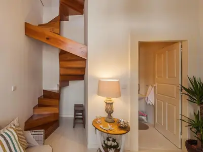 a hallway with a table with a lamp and stairs at Down2Town B&B in Porto