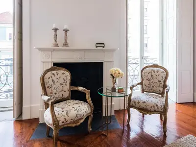two chairs and a glass table in a room with a fireplace at Down2Town B&B in Porto