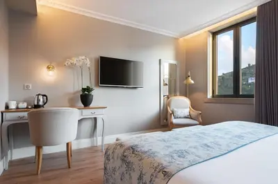 a hotel room with a bed and a desk and a television at Eurostars Porto Douro in Porto