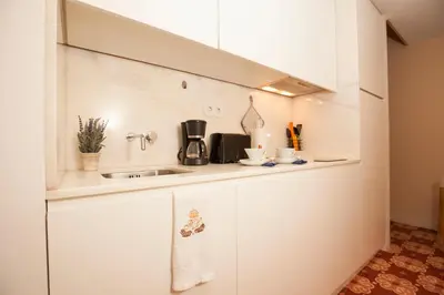 a kitchen with white cabinets and a sink at ML Apartments Story in Porto