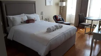 a bedroom with a large white bed with two towels on it at ML Apartments Story in Porto