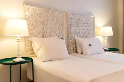 a bedroom with a white bed with two lamps at BmyGuest - Santa Catarina Downtown Apartment in Porto
