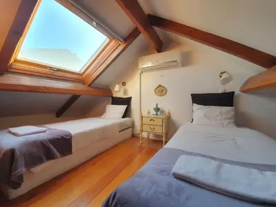 two beds in a attic room with a window at Porto Alegria Garden in Porto