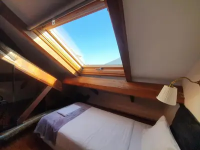 a bedroom with a window with a bed and a lamp at Porto Alegria Garden in Porto