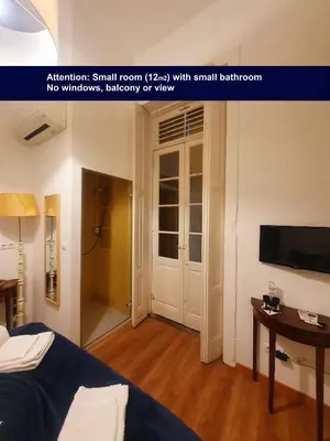 a small room with a bed and a small bathroom at Porto Alegria Garden in Porto