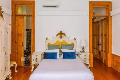 a bedroom with a large white bed with blue pillows at Porto Alegria Garden in Porto