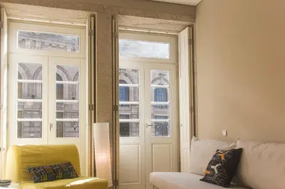 a living room with a couch and two windows at BmyGuest - Cardosas Stylish Apartment in Porto