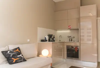 a living room with a couch and a kitchen at BmyGuest - Cardosas Stylish Apartment in Porto