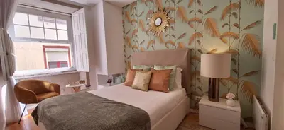 a bedroom with a bed with a flower patterned wall at Oporto Golden View Ribeira in Porto
